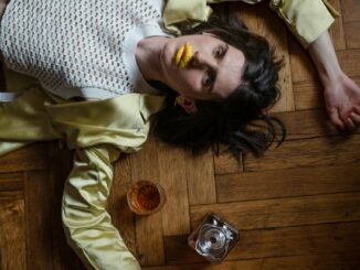 man laying on the floor and whiskey