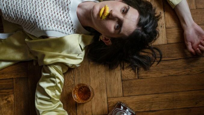 man laying on the floor and whiskey